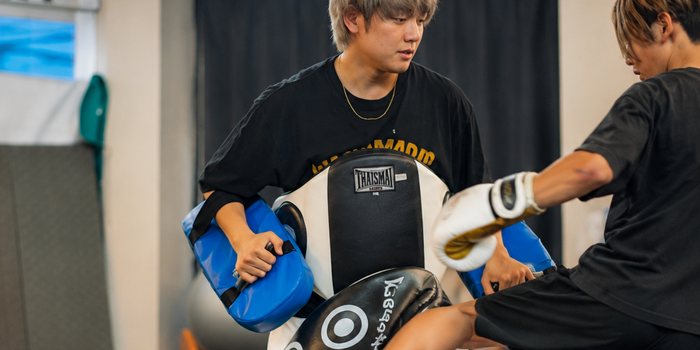 ボディシールドを構えるトレーナーに蹴りを入れるパーソナルトレーニング