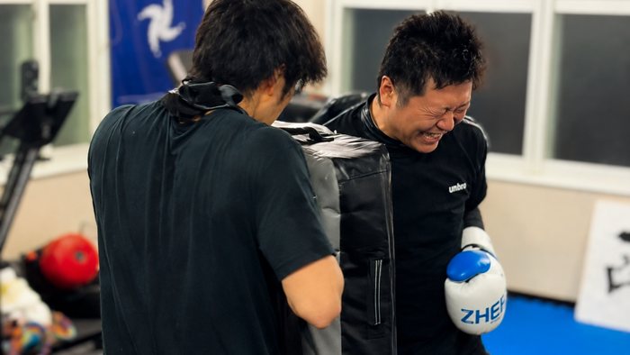 ミットを構える人と打ち込む人。練習中の和やかな一場面